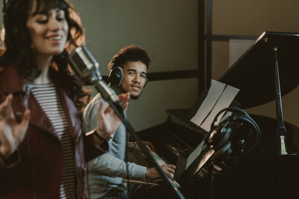 istock young handsome piano player looking at singer performing song 940462150