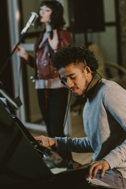 istock young african american musician playing piani while singer performing song on background 940462478