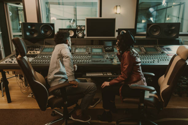 istock sound producers sitting at recording studio and discussing 940463558