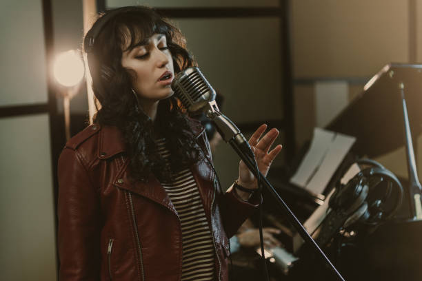 istock sensual female singer performing song at recording studio 940466564