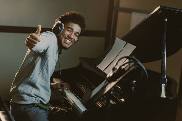 istock happy young piano player showing thumb up 940469090
