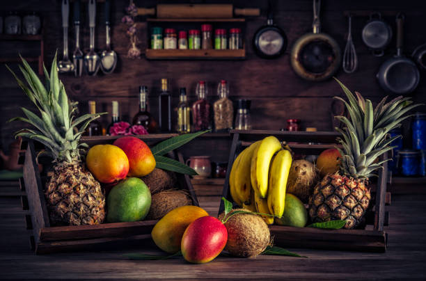 istock Wooden crates with assorted tropical fruits in rustic kitchen. Natural lighting 940471952
