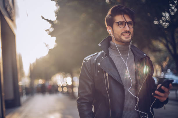 istock Handsome man listening music outdoors 940472804