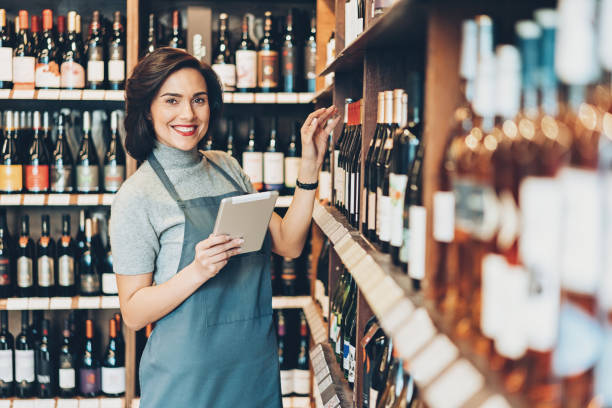 デジタル タブレットをワイン ショップのオーナー - wine cellar liquor store wine rack ストックフォトと画像