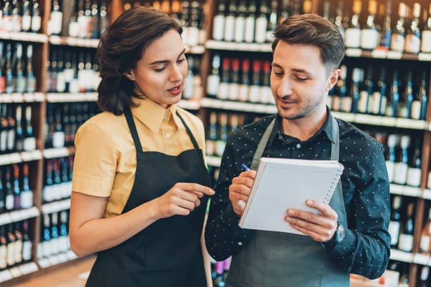 istock Wine shop owners writing in a textbook 940475818