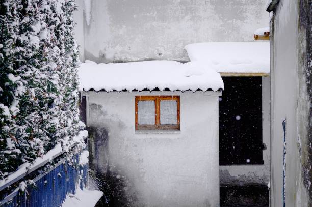 istock Isolated window with white curtains under a snowy roof (Pesaro, Italy) 940476078