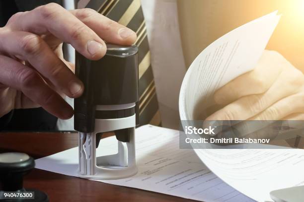 The Businessman Puts A Stamp On The Contract Stock Photo - Download Image Now - Intellectual Property, Rubber Stamp, Document