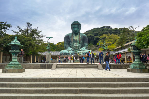 touristes à la statue de la grand bouddha de kamakura, japon - kamakura japan tourist people photos et images de collection