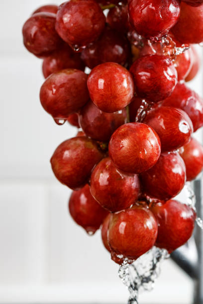 istock drops of water flow down from a bunch of red grapes 940476418