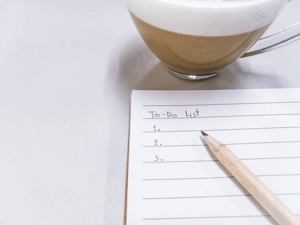 istock to do list write down on blank notebook by pencil. cup of coffee put beside notebook. 940479336