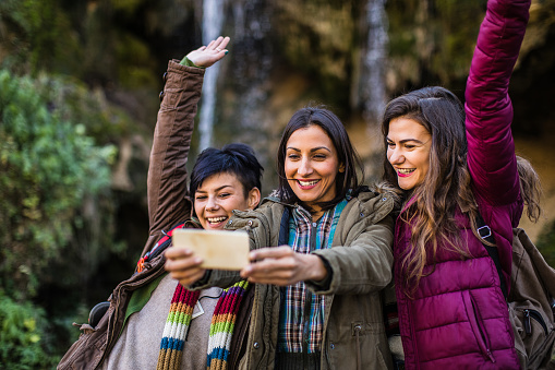 Friends in nature taking a photo in nature smiling