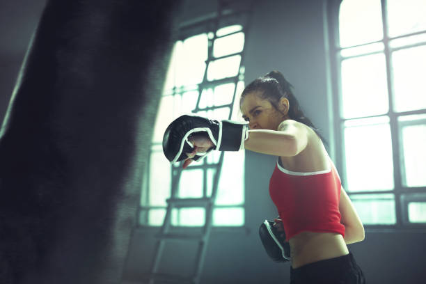 istock Young woman boxing workout in an old dark gym 940485516