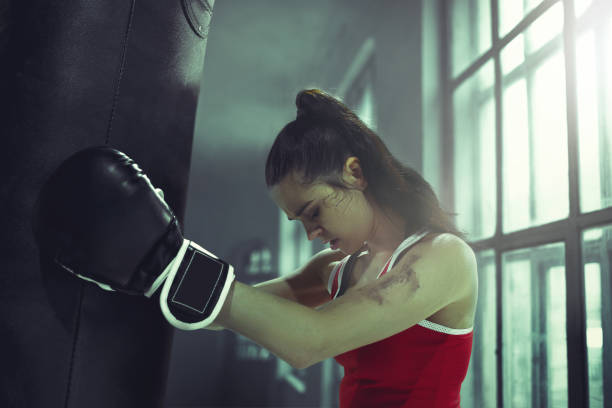 istock Young woman boxing workout in an old dark gym 940485592