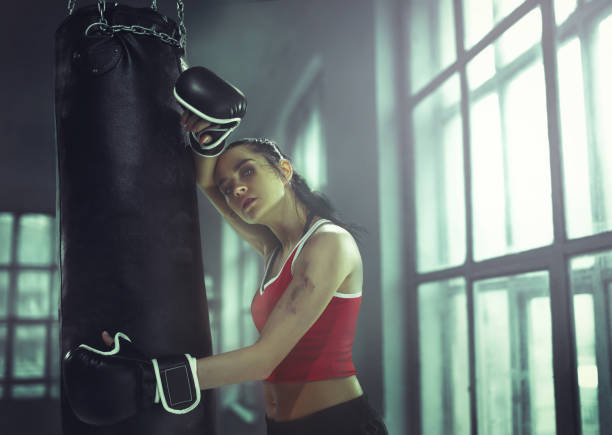 istock Young woman boxing workout in an old dark gym 940485616