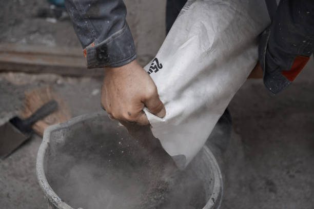 Construction worker pouring the cement to the bucket stock photo