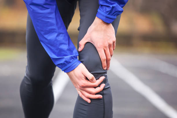 istock Cropped shot of a young runner holding his injured knee while running. 940487782