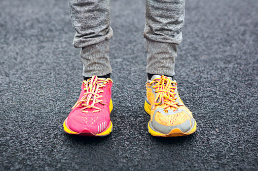 Legs in multi-colored running shoes.