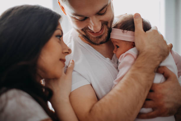 istock Happy parents playing with their newborn daughter 940502334