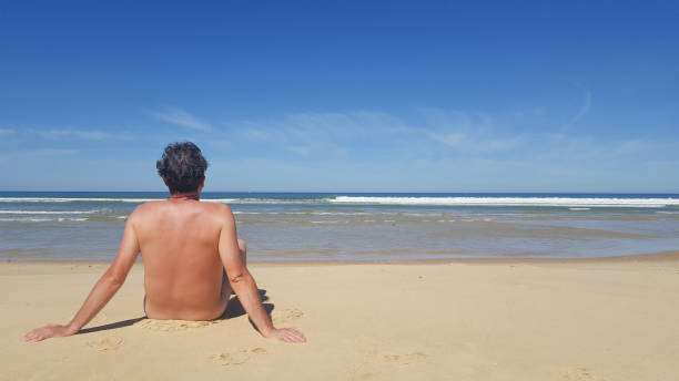 photo d’un homme nu assis tout seul sur la plage - men naked water male photos et images de collection