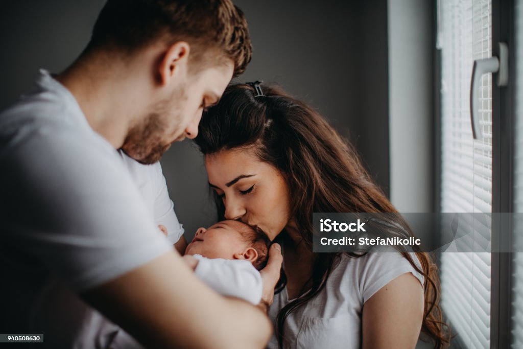 Lachende jonge ouders met hun babymeisje thuis - Royalty-free Baby Stockfoto