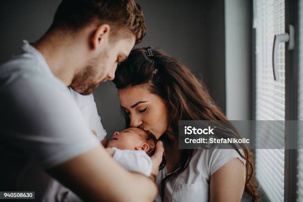 Lachende Jonge Ouders Met Hun Babymeisje Thuis Stockfoto en meer beelden van Baby - Baby, Pasgeborene, Ouder