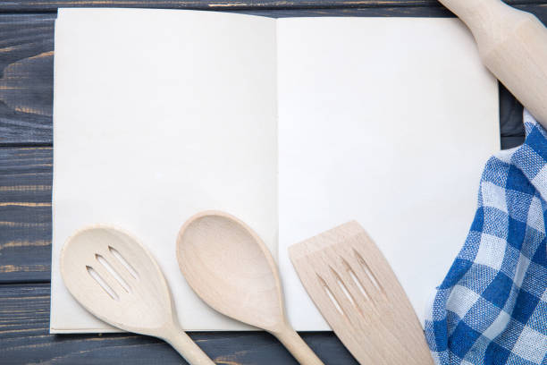istock Kitchen utensil and notepad over wooden table background 940509186