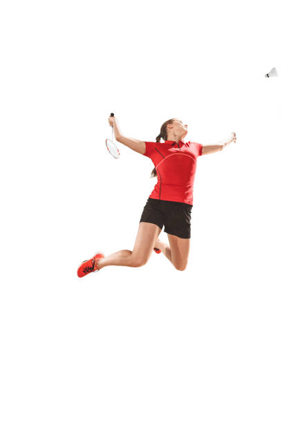 Young woman playing badminton over white studio background. Fit female athlete isolated on white. badminton player in action, motion, movement. attack and defense concept