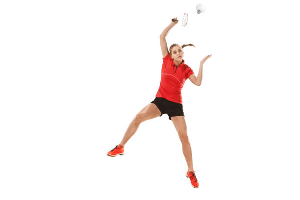 istock Young woman playing badminton over white background 940511284