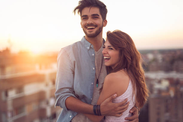 istock Couple in love on a building rooftop at sunset 940518768