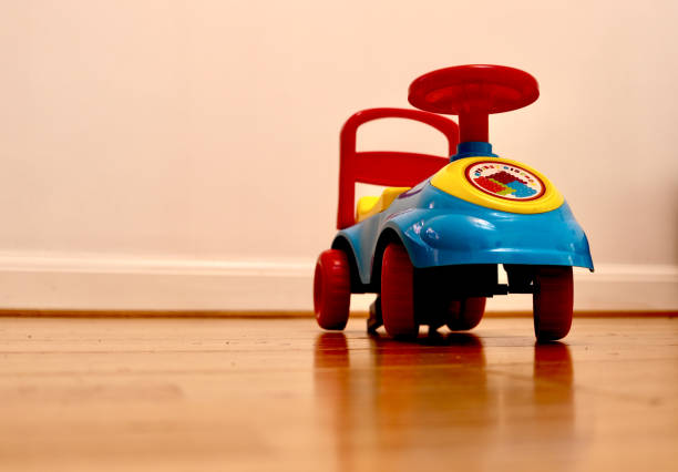 istock Toy car on wooden floor with white blank wall in background 940519314