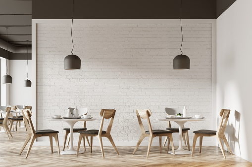 White cafe interior with a wooden floor, round white tables and gray and wooden chairs. 3d rendering mock up