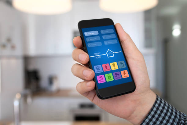 istock man hand holding phone with app smart home background kitchen 940531250