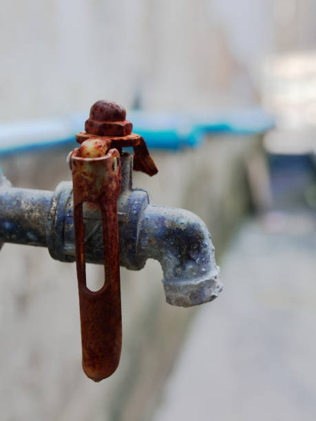 istock Old rustic faucet from blue plastic pipe with red handle and brass spout in retro or vintage style 940531936