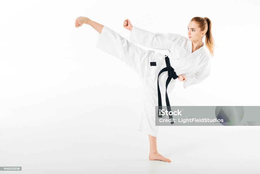 female karate fighter training kick isolated on white Karate Stock Photo