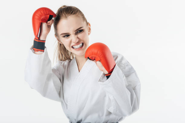 istock female karate fighter training with gloves and mouthguard isolated on white 940535510