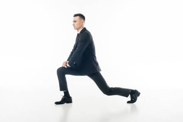 istock businessman stretching legs in suit isolated on white 940536224