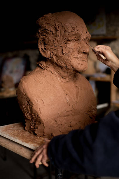 istock Sculptor's hand working on clay bust detail 940548312
