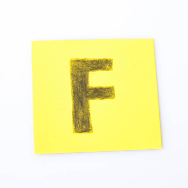 istock F alphabet letter handwrite on a yellow paper composition 940549272