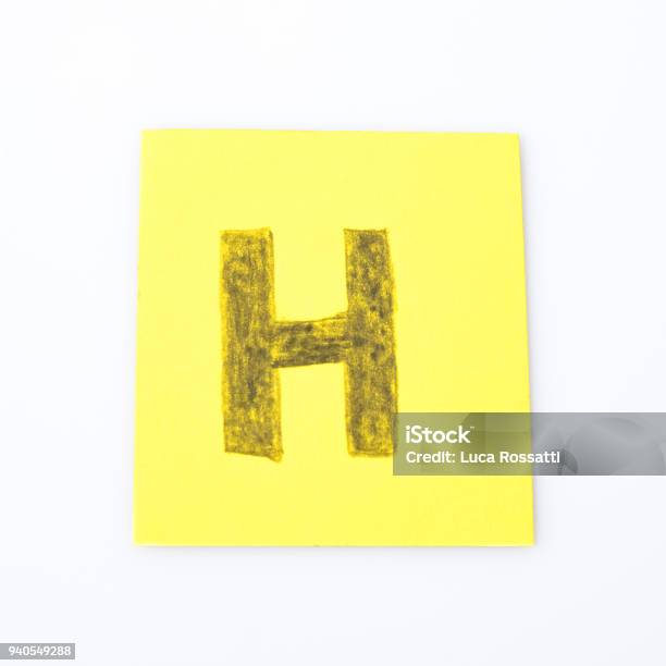 H Alphabet Letter Handwrite On A Yellow Paper Composition Stock Photo - Download Image Now