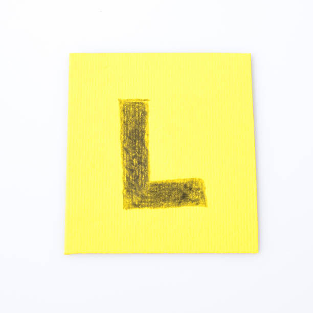 istock L alphabet letter handwrite on a yellow paper composition 940549362