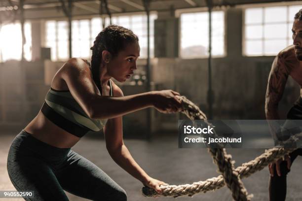 Mujer Haciendo Ejercicios De Cuerda De Batalla En El Gimnasio Foto de stock y más banco de imágenes de Ejercicio físico