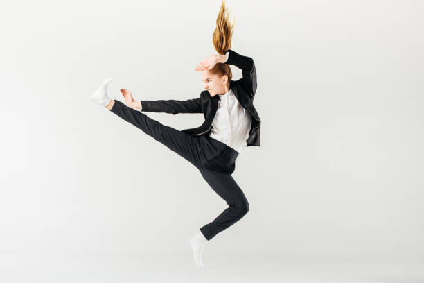 istock female karate fighter jumping and performing kick in suit isolated on grey 940556160