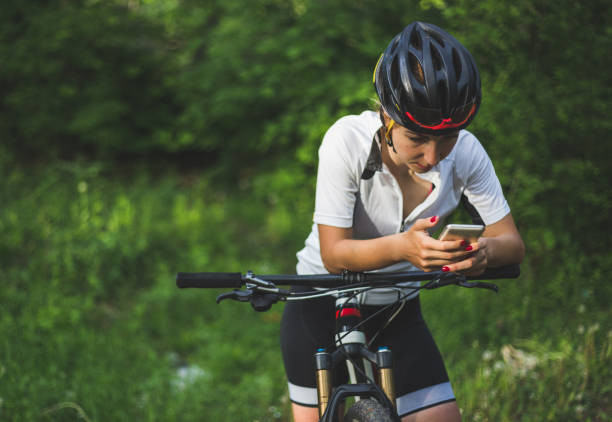 istock Sporty woman, cyclist, using navigation on smartphone 940560346