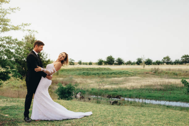 istock Beautiful bride and groom in a park. 940564890