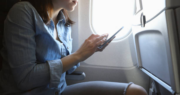 istock Young woman on airplane sends text before take off 940568424