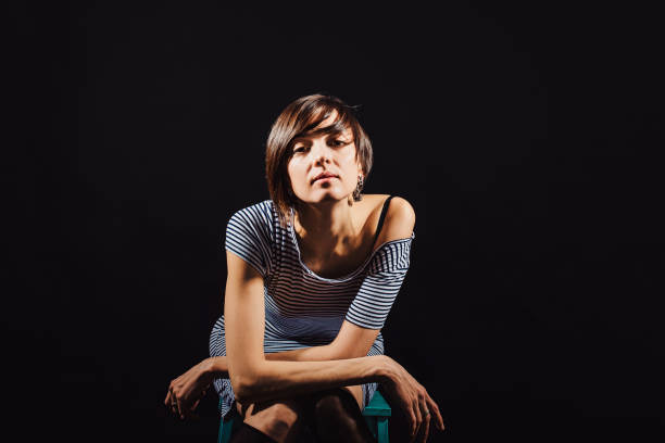 istock Brunette in a striped dress on a black background 940577522