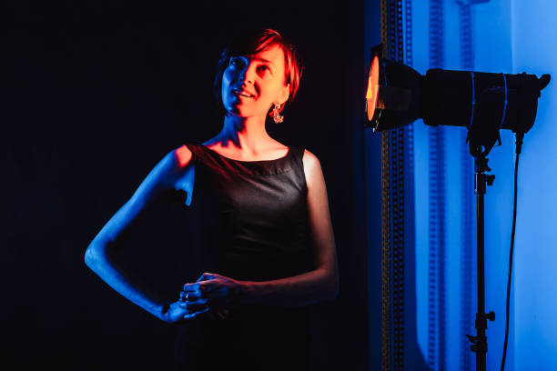 istock Brunette in a black dress on a black background. 940577690
