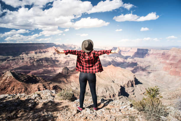istock Young Woman Overlooking The Grand Canyon 940582616