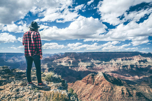 istock Young Woman Overlooking The Grand Canyon 940582638