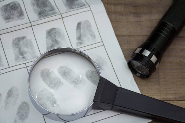 istock Fingerprints on paper with a magnifying glass 940582954